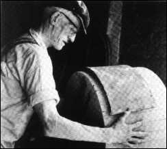 A saggar-maker at making the side of a saggar on a wooden former.