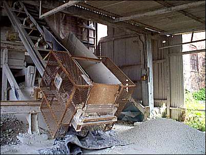 The raw white clay is shoveled onto this conveyor